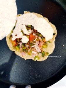 Add layer of batter Adding another layer of batter on the uttapam and the veggies